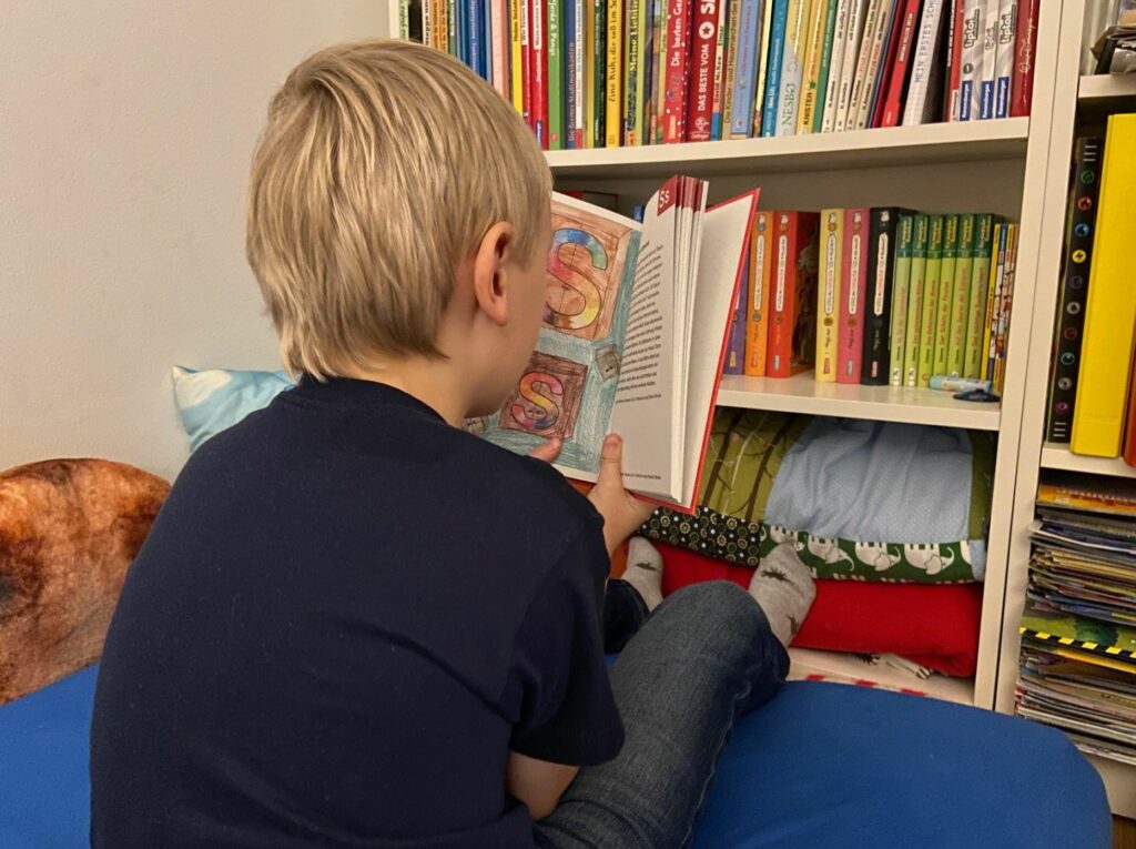 Kind liest aus "Das erste Buch"