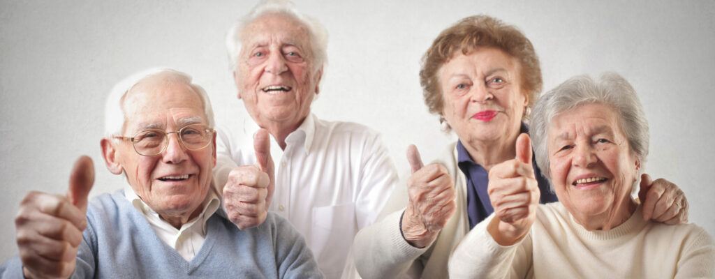 Barrierefreiheit: Gruppe von lachenden Senioren zeigt Daumen nach oben