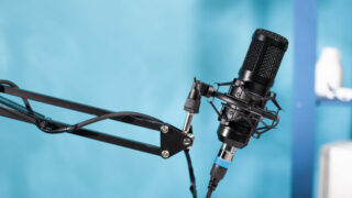 Nahaufnahme eines professionellen Mikrofons vor blauem Hintergrund
