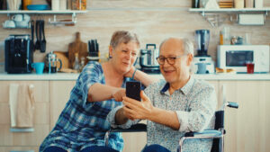Älteres Pärchen guckt zusammen auf ein Smartphone