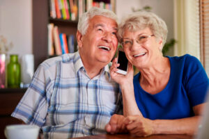 Älteres Paar telefoniert gemeinsam mit einem Smartphone