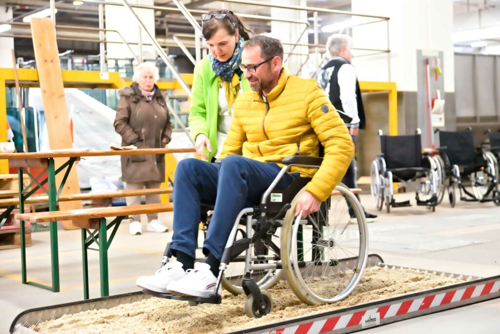 Menschen nutzen den Rollstuhl- und Blindenparcours