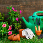 Gartenutensilien vor einem Gartenzaun