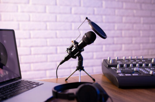 Mikrofon neben einem Laptop und Mischpult