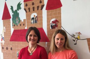 Die zwei Mitarbeiterinnen des QBZ Robinsbalje stehen vor einem Wandbild