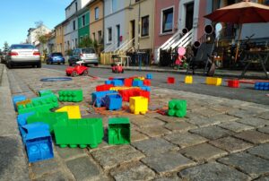 SpielLandschaftStadt: Temporäre Spielstraße, bei der Spielzeug auf der Straße liegt