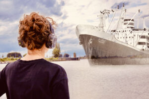Eine Frau mit Kopfhörern beobachtet ein halbdurchsichtiges Frachtschiff im Wasser