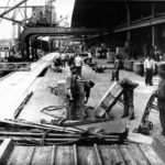 Hafenarbeiter mit Fracht auf Sackkarren im Hamburger Hafen um 1900
