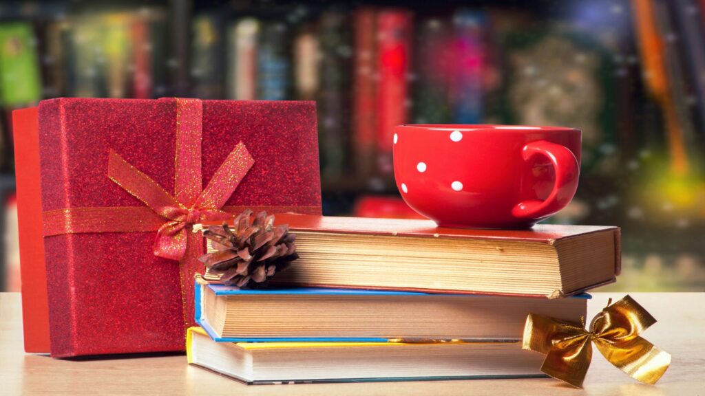 Buchtipps für Weihnachten: ein Stapel Bücher, eine rote Tasse und ein Geschenk rot eingepackt