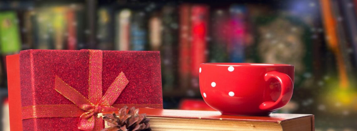 Buchtipps für Weihnachten: ein Stapel Bücher, eine rote Tasse und ein Geschenk rot eingepackt