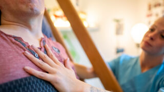 Symbolbild für Friedehorst: eine Pflegerin legt die Hand auf die Brust eines pflegebedürftigen Mannes