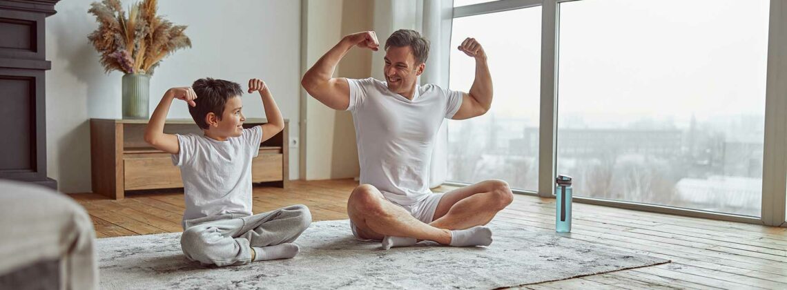Vater und kleiner Sohn zeigen ihre Muskeln