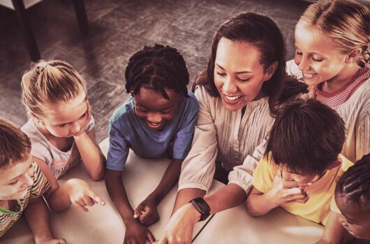Kinder sitzen lachend gemeinsam am Tisch