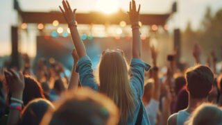 Eine Crowd vor einer Open Air Bühne in der Dämmerung