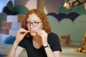 Universum "Sommersause": ein Mädchen pustet in eine selbst gebaute Papierflöte