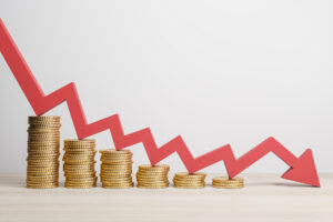 Das Foto zeigt Haufen von Geldmünzen, die immer kleiner werden. Darüber liegt ein roter Abwärtspfeil. Symbolbild für Inflation, Rudolf Hickel im Interview