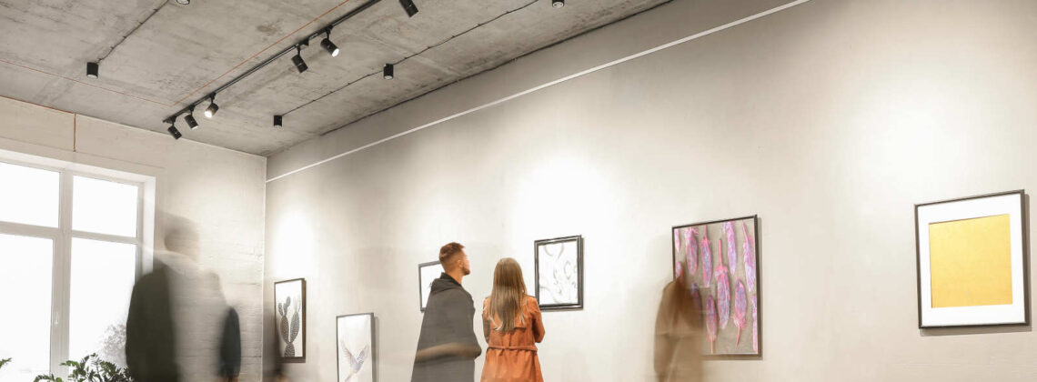 Menschen in einem Museum, die sich Bilder an den Wänden ansehen