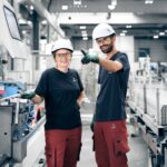 Eine Mitarbeiterin und ein Mitarbeiter stehen in den Werkshallen von Hydro in Bremen. Hydro nimmt an der Langen Nacht der Industrie 2025 in Bremen teil. 