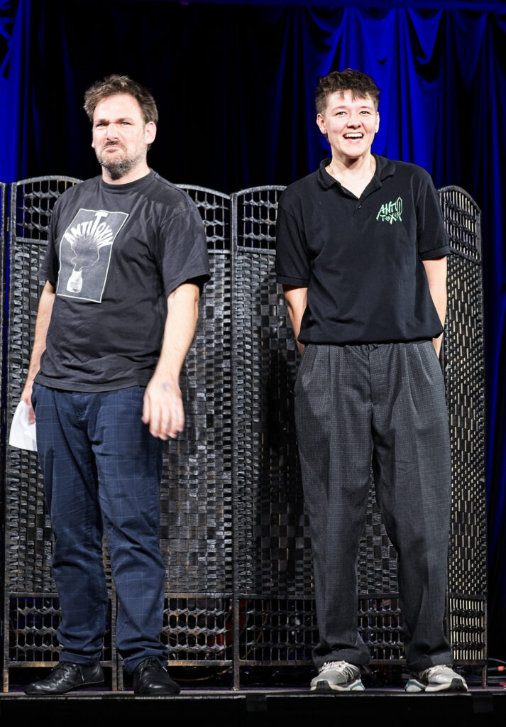 Mathias Hilbig und rechts daneben Annik Ahrens, stehen in AntiToxin-T-Shirts auf der Bühne bei der Jubiläumsgala