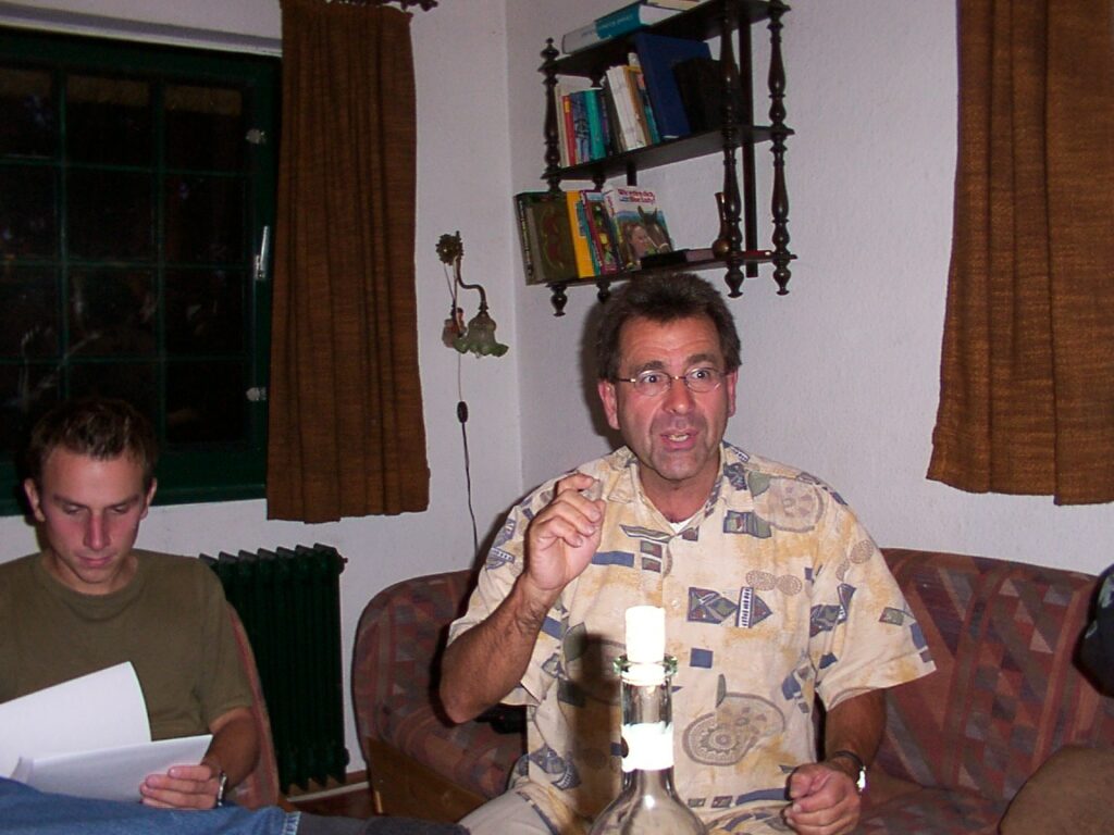 Foto aus Borchel, zu sehen ist Reinhard Schilling mitten im Satz, die Hand gehoben, neben ihm Schüler Tilman Gothner, der fokussiert in eine Mappe blickt