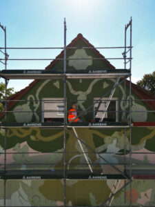 Eine Künstlerin bei der Arbeit ihrer Fassadenkunst