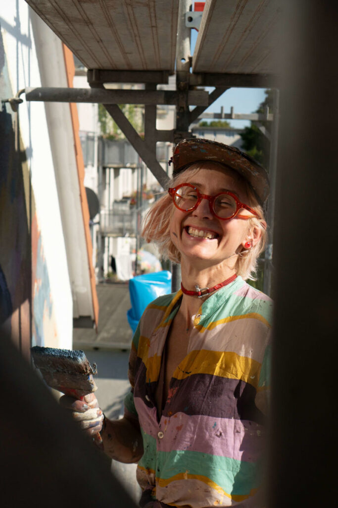 Nahaufnahme der Künstlerin Lina Besedina, die herzlich lächelt