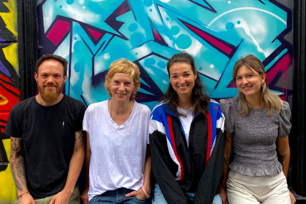 Das vierköpfige Beratungsteam für den Trauerland-Pop-Up im Bremer Viertel vor einer Graffitiwand