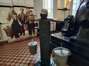 Ausstellungstück im Museum: Jungen tragen Eimer mit Fäkalien weg