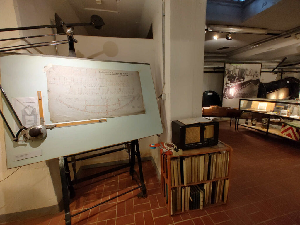 Blick in die Ausstellungsräume mit Zeichentafel und anderen Gegenständen.