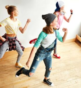 Drei Jugendliche Mädchen machen Tanzbewegungen. Symbolbild für Tanzkurse für Kinder und Jugendliche in Bremen.