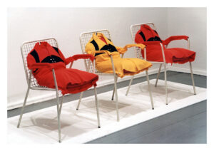 Drei Stühle auf denen Jacken sitzen, Kunstinstallation der Künstler*innengruppe Die Tödliche Doris