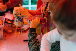 Kinder basteln an einem Tisch beim Tag för Lütte im Zentrum für Kunst Bremen.