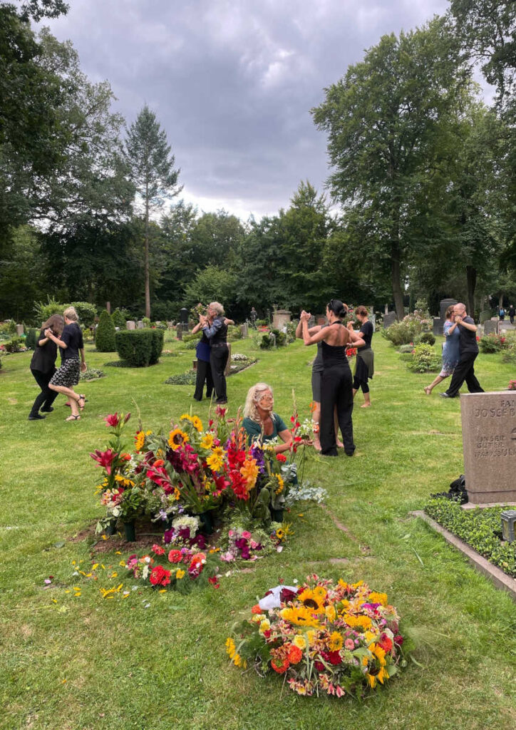 Menschen tanzen Tango auf einem Friedhof, schöner Abschied von einer verstorbenen Person