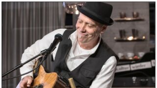 Ein Mann der auf seiner Gitarre spielt