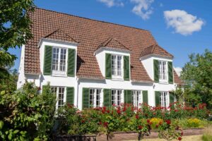 Weißes Gebäude mit grünem Fensterläden und Garten, Sitz der Deutschen Klimastiftung in Bremen.