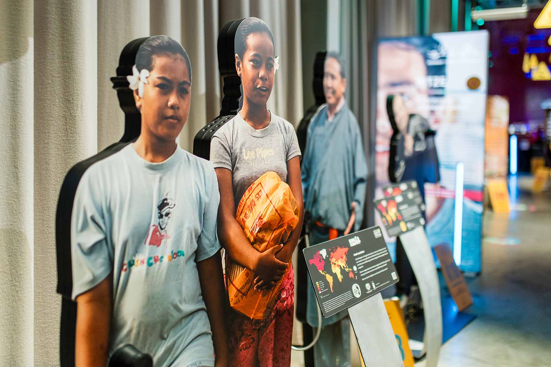 Lebensgroße Figuren in einer Ausstellung, die Menschen aus verschiedenen Regionen der Welt darstellen.