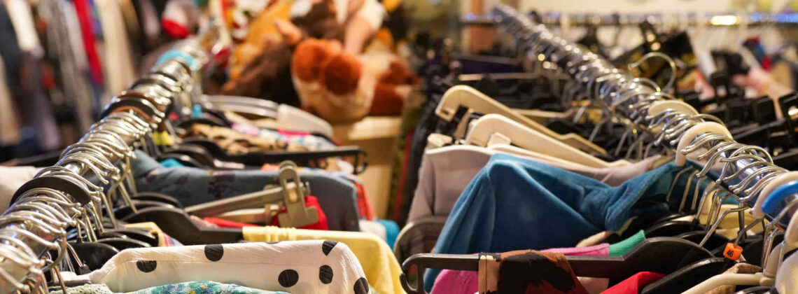 Nahaufnahme zweier Kleiderstanden voll mit Second-Hand-Kleidung
