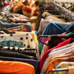 Nahaufnahme zweier Kleiderstanden voll mit Second-Hand-Kleidung