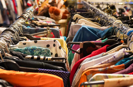 Nahaufnahme zweier Kleiderstanden voll mit Second-Hand-Kleidung
