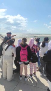 Gruppe junger Menschen bei einem Ausflug an die Nordseeküste während einer geführten Wattwanderung