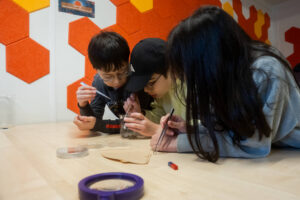 Kinder untersuchen in der MarsBox der Uni Bremen simulierten Marssand.