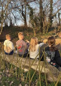 Kinder sitzen nach einer gemeinsamen Backaktion in der Bürgerhaus-Kinderwildnis zur Abschlussrunde zusammen.