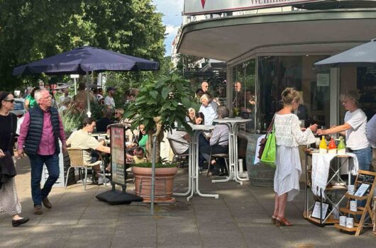 Belebte Wachmannstraße mit Außengastronomie und Marktständen an einem sonnigen Tag in Bremen