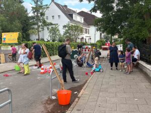 Kinder spielen und fahren Roller auf der Spielstraße während eines Nachbarschaftsfests in der Wachmannstraße