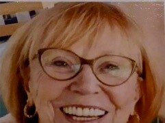 Eine Frau mit Brille die lächelt