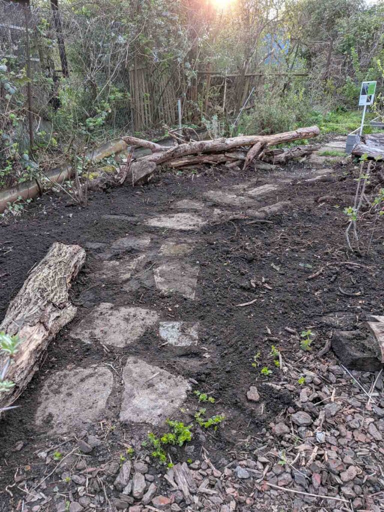 Naturpfad mit Steinen, Erde und Totholz im Klimagarten Findorff