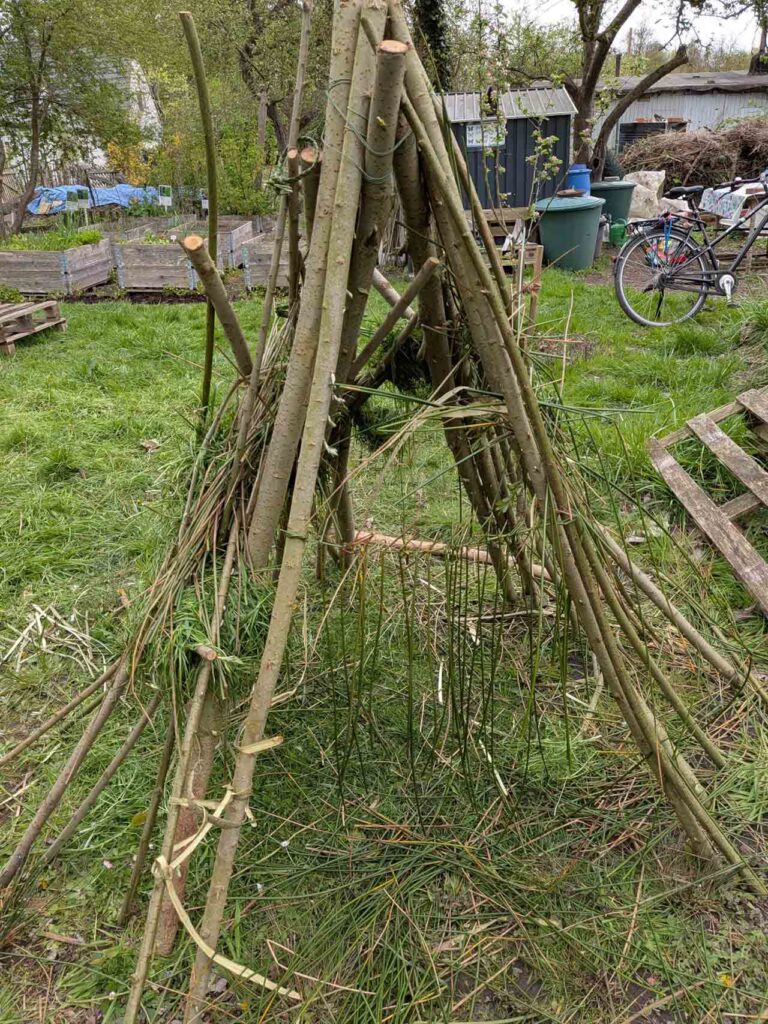 Aus Ästen gebautes Tipi auf der Wiese im Klimagarten Findorff