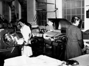 Frauen arbeiten vor 100 Jahren in der Wäscherei Wartberg an einer alten Mangel