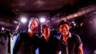 Drei Männer. Musik Band. Lächeln auf der Bühne.