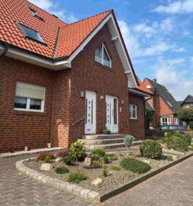 Das Symbolbild für das Thema Finanzierung Immobilien Bremen zeigt ein modernes Friesenhaus in Rotklinker.